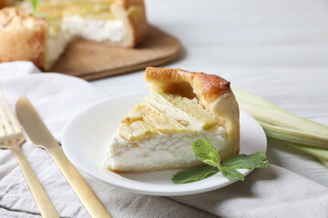 Piece of freshly baked rhubarb pie with cream cheese and cutlery on table, closeup