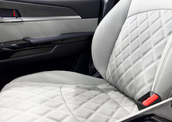 Obraz premium Car white leather interior. Part of white leather car seat details with white stitching. Interior of prestige car. Comfortable perforated leather seats. Perforated leather.