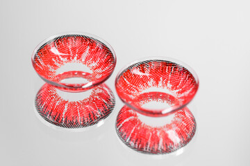 Two red contact lenses on mirror surface
