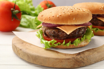 Tasty hamburgers with patties, cheese and vegetables on white wooden table, closeup