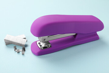 Bright stapler with staples on light blue background
