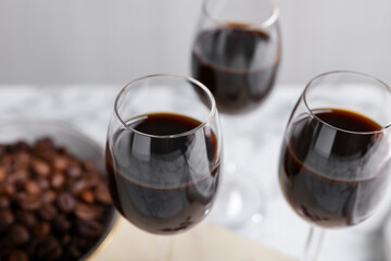 Glasses of coffee liqueur on blurred background, closeup