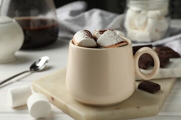 Fototapeta na wymiar Cup of aromatic hot chocolate with marshmallows and cocoa powder on table, closeup