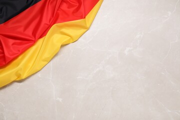 Flag of Germany on beige marble background, top view. Space for text