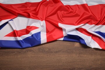 Flag of United Kingdom on wooden background, top view. Space for text