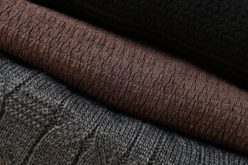 Closeup view of different casual folded sweaters as background