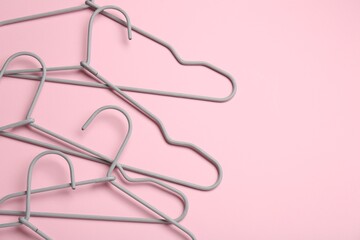 Hangers on pink background, flat lay. Space for text