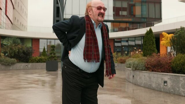 poignant narrative of an elder senior bearded man and an old middle aged grandfather dealing with the abrupt onset of severe back pain attributed to rheumatism, evident in their expressions, outdoor
