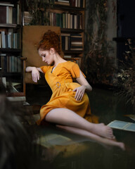 A girl in a flooded room sits on the floor in the water