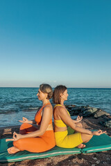 Fototapeta na wymiar Yoga instructor with a student practice yoga on the beach