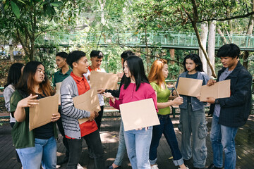 Group of activist discussing and talking while holding blank cardboard during a rally or demonstration - obrazy, fototapety, plakaty