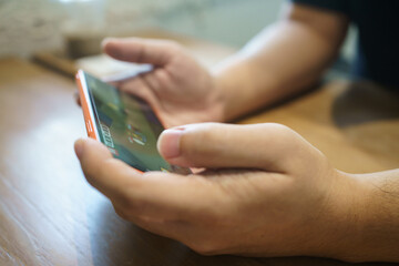Man playing game on mobile phone. gamer boy playing video games holding Smartphone working mobile...