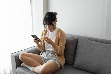 Asian woman Search for information on Internet in smartphone with holding bottled drug. girl...