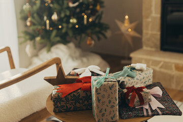 Merry Christmas! Stylish christmas gifts wrapped in festive paper with bows and vintage ribbons on...