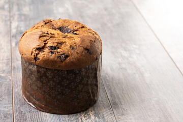 Christmas panettone cake with chocolate chips on wooden table. Copy space