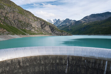 Obraz na płótnie Canvas Spillway of Moiry Dam and turquoise water of Lac de Moiry, at the head of the Grimentz Valley, Switzerland, with snow capped mountains and Moiry Glacier in the back.