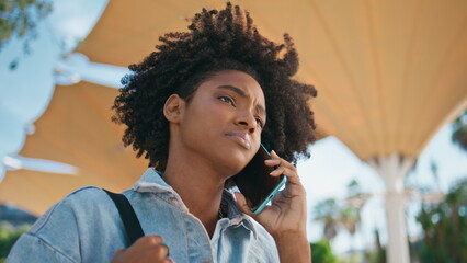Black haired girl calling cellphone walking street closeup. Teenager talking