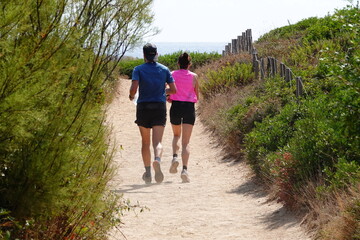 Un couple pratiquant le running en pleine nature - 684575801