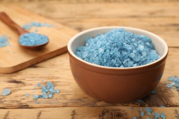 Bowl with blue sea salt on wooden table, closeup