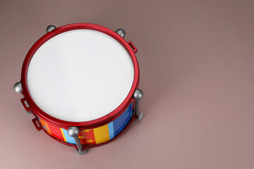 Colorful drum on dusty rose background, above view with space for text. Percussion musical...