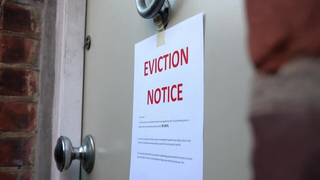 Low shot of eviction notice being placed onto door