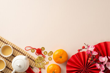 Chinese New Year's beauty from top view: fans, Feng Shui treasures, teapot set, and green tea—an...