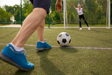 Happy retired people playing football together outdoors at city court