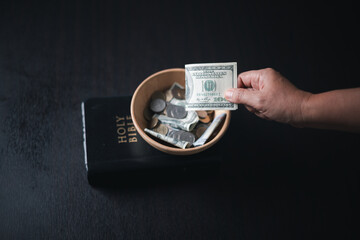 One tenth or tithe is basis on which Bible teaches us to give one tenth of first fruit to God. coins with Holy Bible. Biblical concept of Christian offering, generosity, and giving tithes in church. - obrazy, fototapety, plakaty