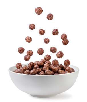 Chocolate corn balls falling into a plate on a white background. Isolated