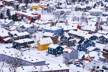 Fototapeta na wymiar Norwegian town of Troms in the winter. Snowy arctic city with colorful houses and port