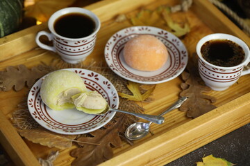 Colorful japanese sweets daifuku or mochi sliced. Sweets close up on the plate with cup of coffee