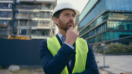 Caucasian pensive adult man heavy metal building industry worker inspector thinking architect...