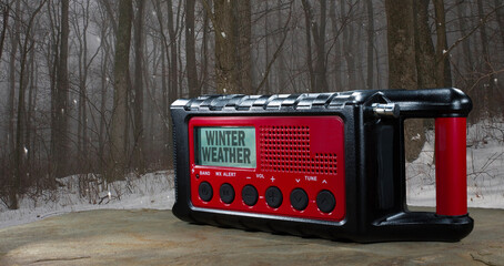 Winter weather warning on an alert radio with snow behind