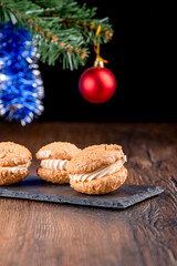Coconut cookies with cream on a mica serving board and blurred New Year's background.