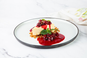 top view of cheesecake with juicy berries and mint on a white plate 