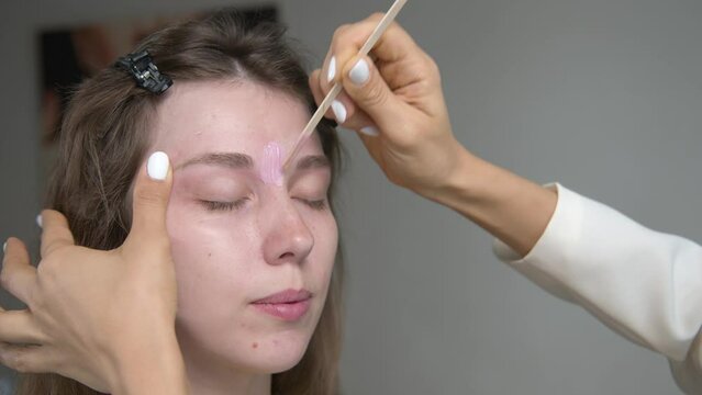 Hair removal, beauty and health concept. A young girl is getting an epilation procedure. A processional beauty worker is making depilation with hot wax