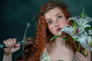 Close-up portrait of a girl in a crown of thorns with a sword and white lilies