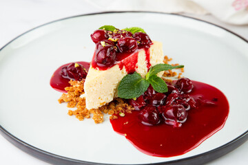 top view of cheesecake with juicy berries and mint on a white plate 