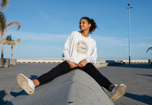 Mockup of woman wearing customizable sweatshirt on wall, legs apart
