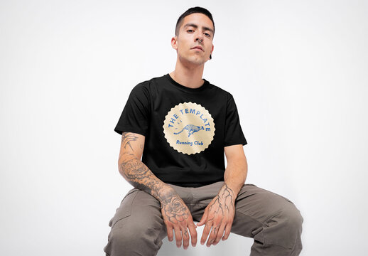 Mockup of man wearing customizable t-shirt in studio with tattoos