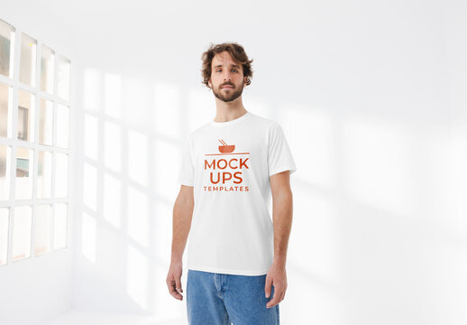 Mockup of man wearing customizable t-shirt by window in studio