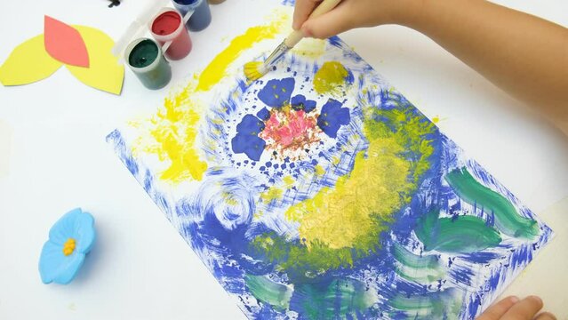 Little girl coloring colorful abstract with flowers. Early development.  Children's creativity . The concept of a happy childhood.