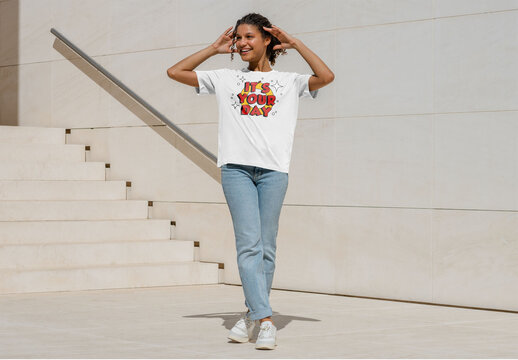 Mockup of woman wearing customizable t-shirt by steps, arms raised