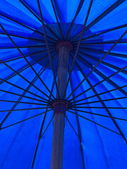 Fototapeta premium blue umbrella on the background of the sun.