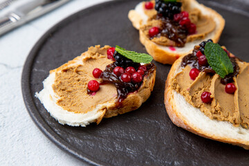canapes with pate, mint leaves and berries, side view