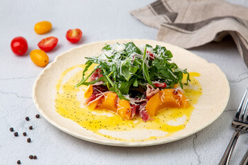 green salad with arugula and lingonberries on a white plate and marble background side view