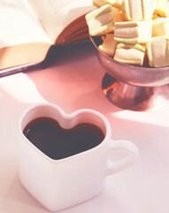 Morning still life, coffee in bed. White cup in shape heart.  Cozy home concept. Rustic style, Lazy weekend. Falling in love