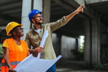 Shot of a young man and woman going over building plans at a construction site. Civil Engineers...