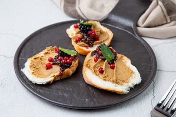 canapes with pate, mint leaves and berries, side view