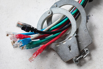 Closed handcuffs on network wires, concept on the theme of punishment for crimes on the network